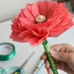 Fully assembled tissue paper flower with green floral tape stem and pearl center