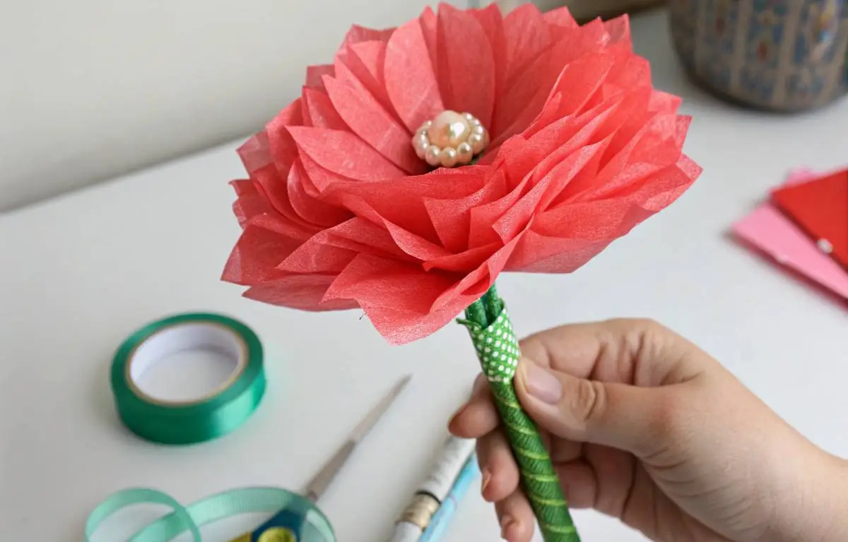 Fully assembled tissue paper flower with green floral tape stem and pearl center
